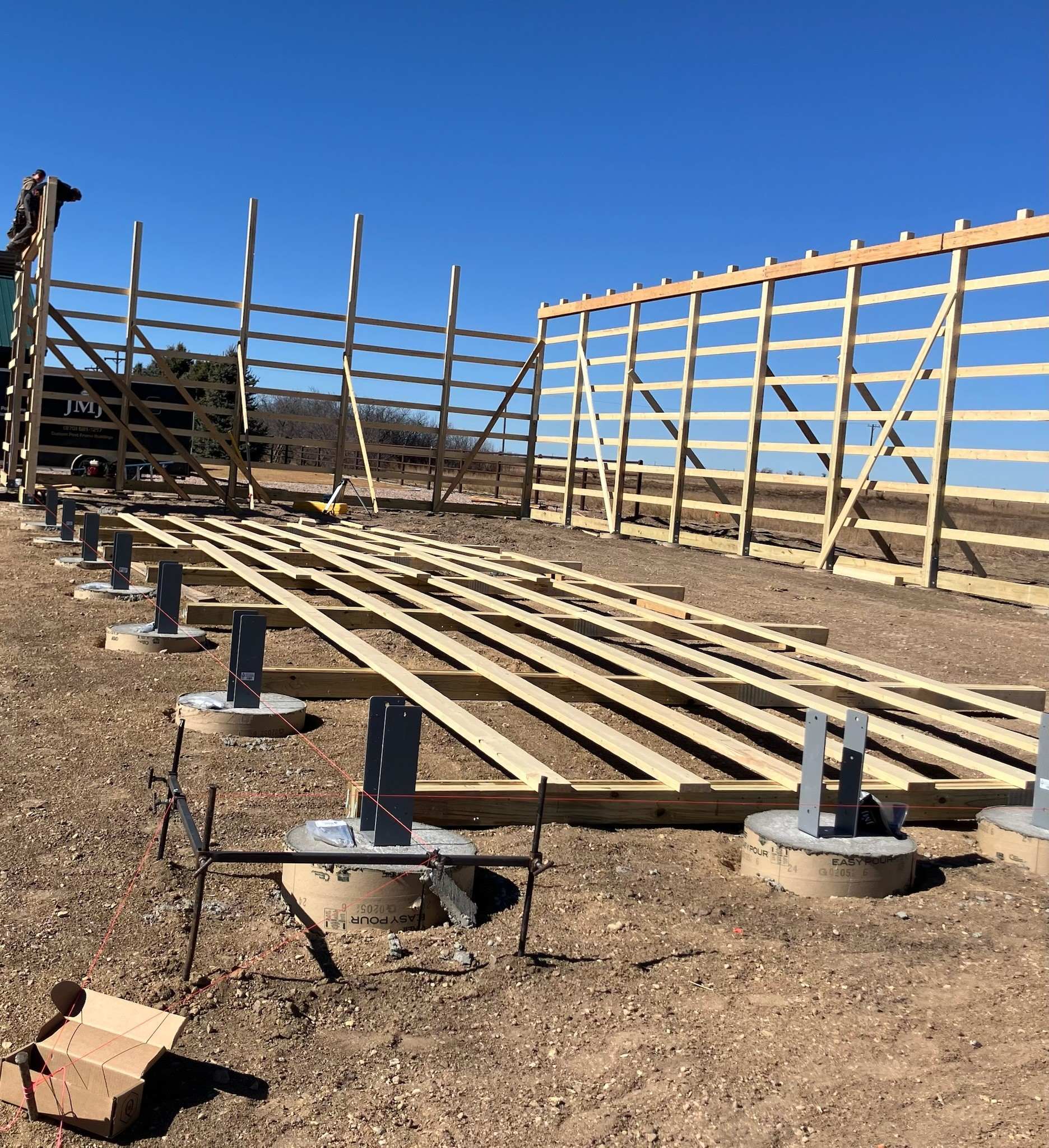 Permanent concrete pier foundation with Sturdi-Wall steel post brackets keeping posts above grade